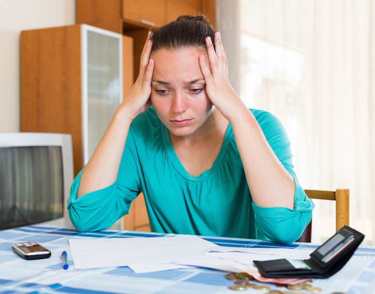 thoughtful girl sits with her bills on the table